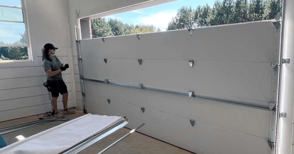 Technician installs new sectional garage door.